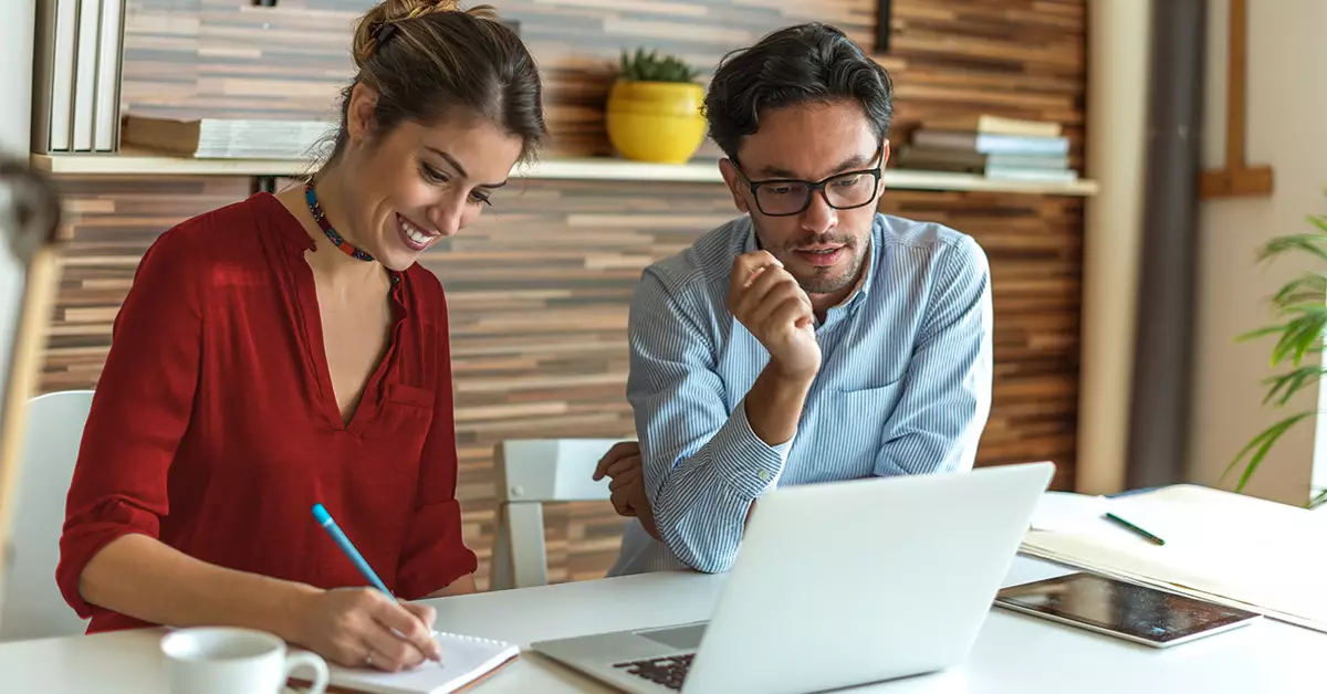 Man and woman collaborating and looking at a computer