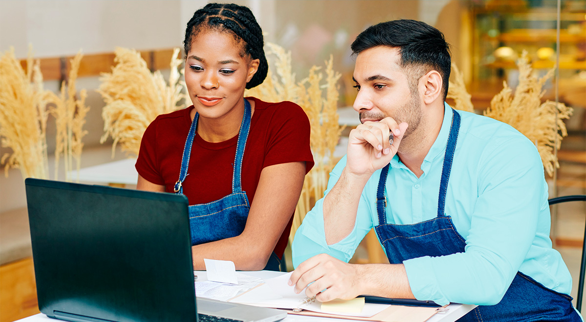 Two coworkers conversating and looking at a computer