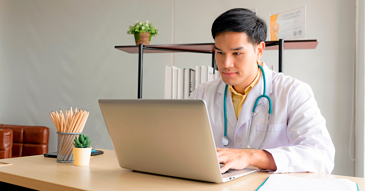 Doctor in an office looking at a computer