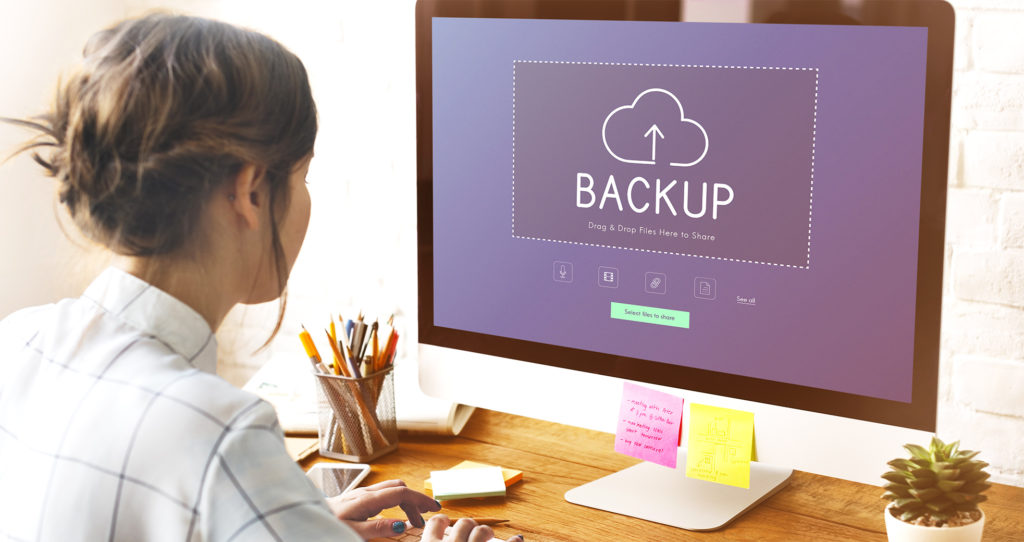 Woman sitting at a computer backing up files