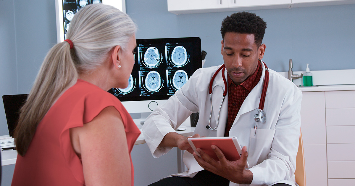 Doctor looking at a tablet having a discussion with a patient