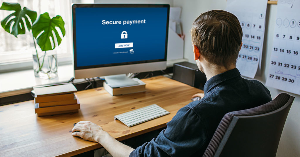 A person sitting at a computer making an online payment