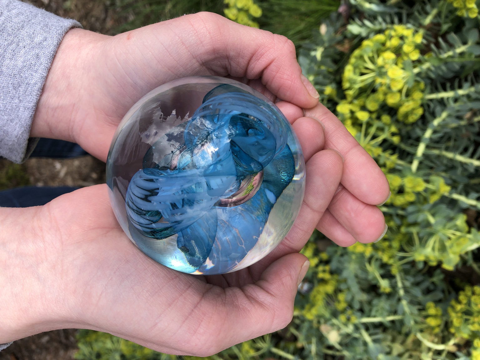 Person holding a hand-blown piece of glass art