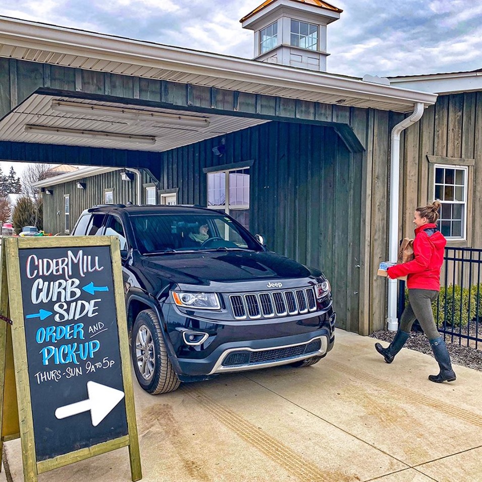 Someone bringing a to-go order out to a car