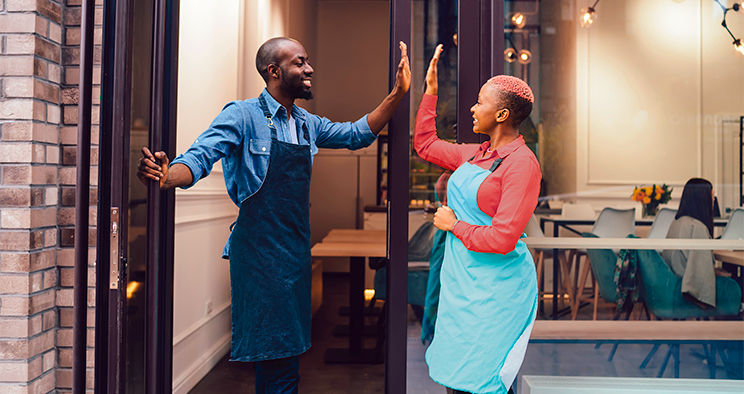 Two business owners excited and high-fiving