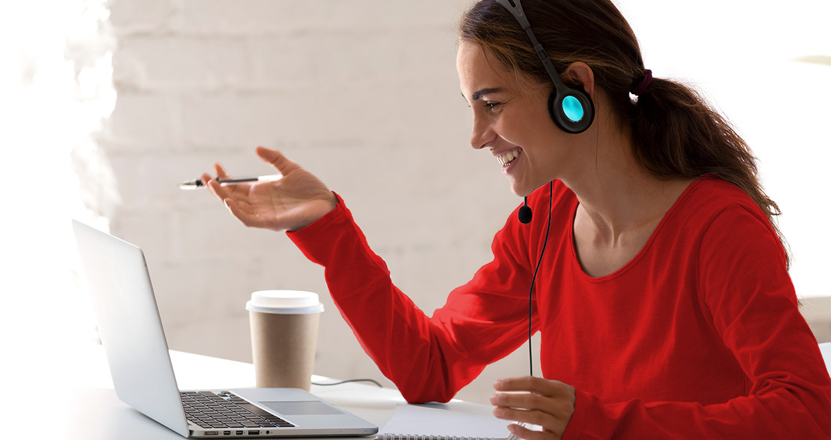 A woman sitting at a computer talking on a webinar