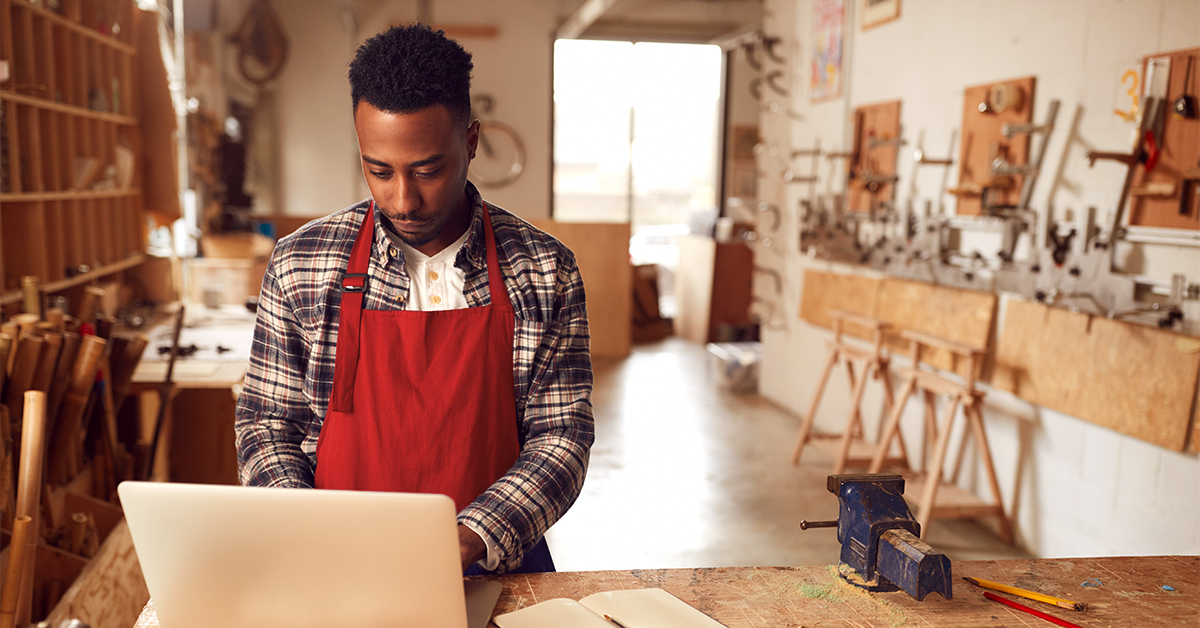 A man working on a computer in a wood shop