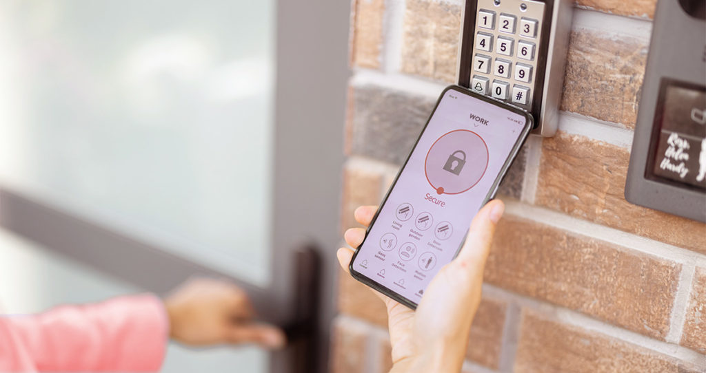 A hand holding a phone up to a keypad