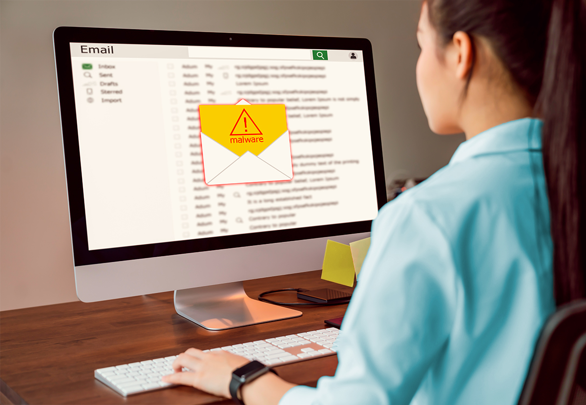 A woman looking at a malware warning on her computer screen