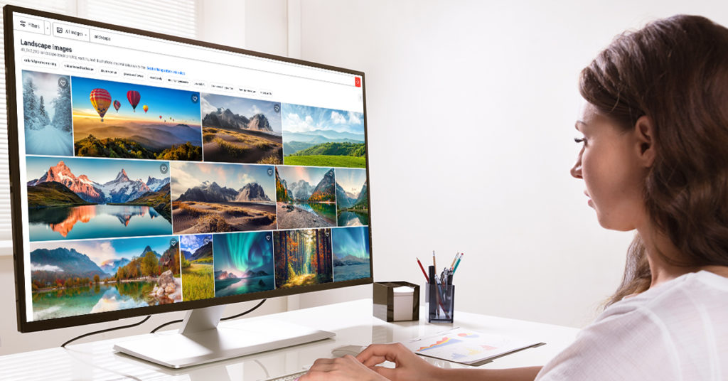 A woman on a computer looking at a stock photo site