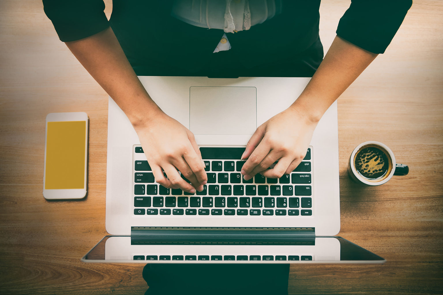 Hands typing on a computer