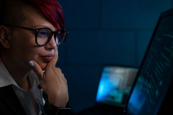 A woman in glasses staring at a computer screen with Secure Pro